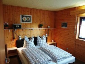 a bedroom with two beds and wooden walls at Haus Sonnenhang in Esch