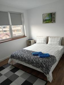 a bedroom with a bed with a black and white blanket at Zen aeroport in Sînnicoară