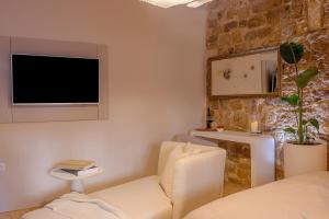 a living room with a couch and a tv on the wall at Studio Palace Gates in Split