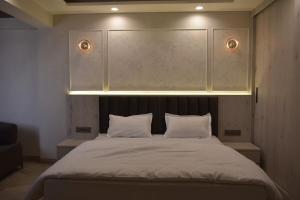 斋浦尔Penthouse in Jaipur by The Sanctum的一间卧室配有一张带两个白色枕头的大床