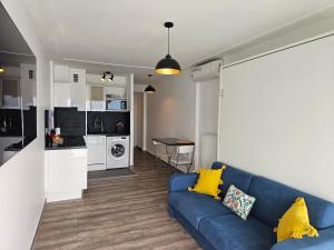 a living room with a blue couch and a kitchen at Le Soleil in Juan-les-Pins