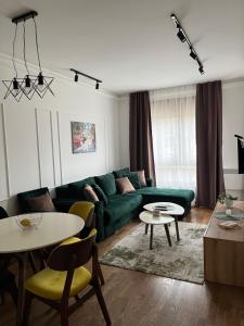 a living room with a green couch and tables at Apartman Natalijina Ramonda in Zlatibor