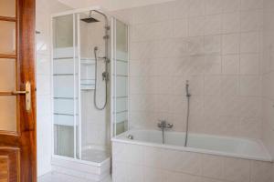 a white bathroom with a tub and a shower at Casa vacanza Nada in Dogliani