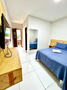 a bedroom with a bed and a flat screen tv at Tambazulik Pousada Maragogi in Maragogi