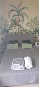 1 dormitorio con 1 cama con papel pintado de palmera en Grand studio Phannie à peine 50m des cures parking wifi balcon vue dégagée, en Amélie-les-Bains-Palalda