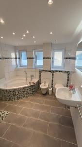 a bathroom with two sinks and a tub and two toilets at Apartment Linda in Tuttlingen