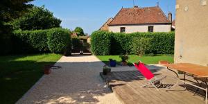 a backyard with a table and chairs and a house at Gite La Mariette 10 couchages Brionnais Charolais in Vauban