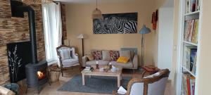 a living room with a couch and a fireplace at Gite La Mariette 10 couchages Brionnais Charolais in Vauban +20 photos