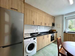a kitchen with a refrigerator and a sink and a dishwasher at Fantastico retiro rural en el corazon de Euskadi in Elgóibar