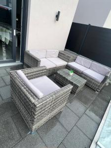 2 sillas de mimbre y una mesa en el patio en FAMILIA GITE, en Ingersheim