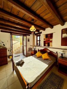 a bedroom with a large bed with yellow pillows at Traditional Cypriot House - Akapanou in Akapnou