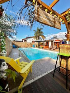 a pool with two yellow chairs and a table at Traditional Cypriot House - Akapanou in Akapnou