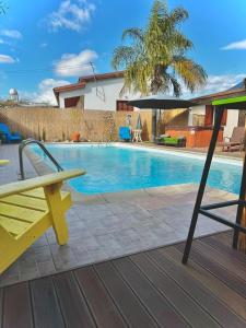 a yellow bench and an umbrella next to a swimming pool at Traditional Cypriot House - Akapanou in Akapnou