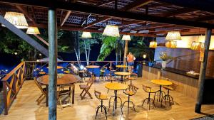 a bar with tables and chairs on a deck at Pousada Casa Dunas in Barreirinhas