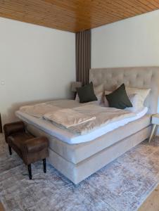 a bedroom with a large bed and a chair at Apartment im Schwarzwald -Natur, Kamin & WLAN, Nähe Baiersbronn in Baiersbronn