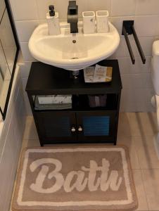 a bathroom with a sink and a bath rug at Apartment im Schwarzwald -Natur, Kamin & WLAN, Nähe Baiersbronn in Baiersbronn +10 photos