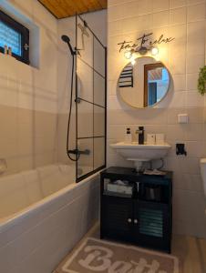 a bathroom with a sink and a tub and a mirror at Apartment im Schwarzwald -Natur, Kamin & WLAN, Nähe Baiersbronn in Baiersbronn