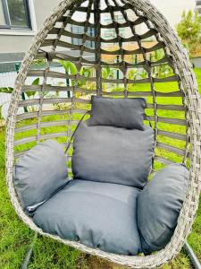 a wicker swing chair with pillows in a yard at Sunny Shores Holiday in Alanya