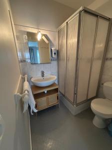 a bathroom with a sink and a toilet and a shower at Hôtel La Coursive Oléron in Saint-Pierre-dʼOléron