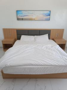 una camera da letto con un letto bianco con due comodini di 中非国际 a Nouadhibou Airport