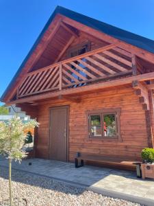 SitnoUrocze domki #1, Domek Sitno 69F KASZUBY的小木屋设有门廊和门