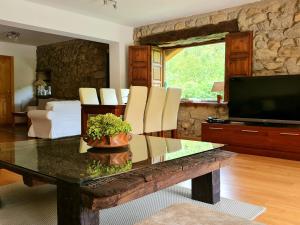 a living room with a table and a tv at El Jardín de la Peña in Castro