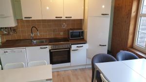 una cucina con mobili bianchi, un lavello e un microonde di Ctiy Home Peine a Peine