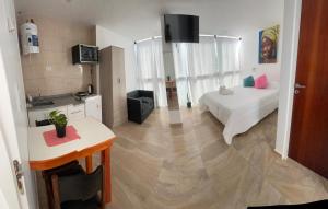 a room with a bed and a table and a kitchen at Departamentos Mon in San Clemente del Tuyú +52 photos
