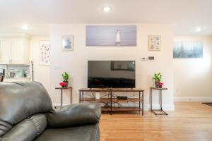 a living room with a leather couch and a television at 41 - 3BR Quincy - Lovely Townhouse near Adams in Quincy