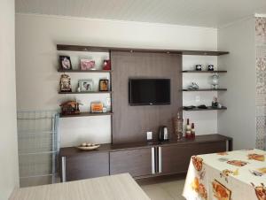 a living room with a television on a wall at Casa da Piscina in Rolante
