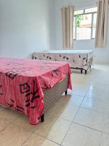 Cette chambre comprend une table avec une couverture rouge. dans l'établissement Casa Clarice, à Caparaó Velho