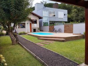 a house with a swimming pool in the yard at Casa da Piscina in Rolante