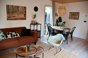 a living room with a couch and a table at Black Cabin Veluwe - Wellness in het bos - Sauna in Putten