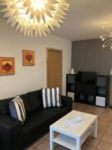 a living room with a black couch and a table at Ferienwohnung Schmitz in Lindlar