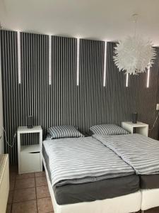 a bedroom with a bed and a black and white striped wall at Ferienwohnung Schmitz in Lindlar