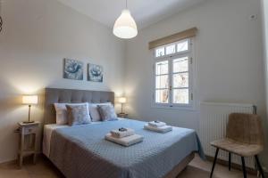 a bedroom with a bed with two towels on it at GG Αpartment in Leonidio