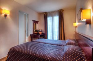 ein Schlafzimmer mit einem blauen Bett in einem Zimmer in der Unterkunft Hôtel De Paris Opera in Paris