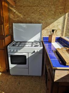 a white stove top oven sitting on top of a counter at Sous les Toiles de PauTiLou in Molles +22 photos