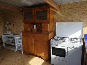 a kitchen with a stove and a white refrigerator at Sous les Toiles de PauTiLou in Molles