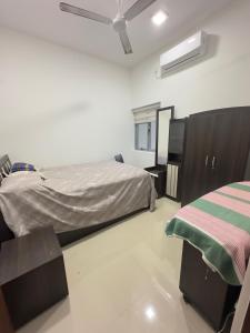 une chambre avec deux lits et un ventilateur de plafond dans l'établissement Canterbury Golf Resort Apartment, à Piliyandala 16 autres photos