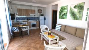 un soggiorno con divano e cucina di Islantilla vistas al mar 1 línea, piscina, parking, wifi a Islantilla