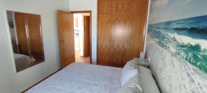 una camera da letto con un letto e un quadro sul muro di Islantilla vistas al mar 1 línea, piscina, parking, wifi a Islantilla