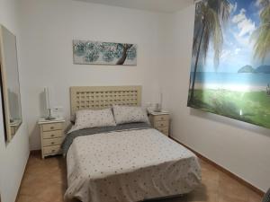 sypialnia z łóżkiem i obrazem na ścianie w obiekcie Islantilla primera linea de playa, piscina, parking w mieście Islantilla