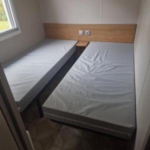 two bunk beds in a small room with a window at Camping de Bayadene in Piriac-sur-Mer +9 photos
