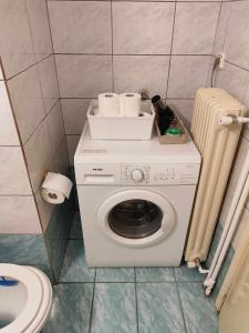 y baño con lavadora y vajilla. en Cathrine's Apartment, en Tríkala