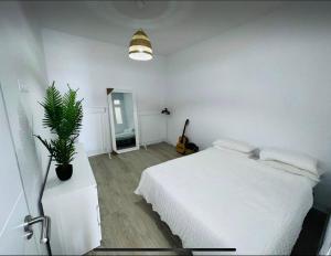 a bedroom with a white bed and a potted plant at Vistabella - Las Vistas Beach, Los Cristianos in Arona