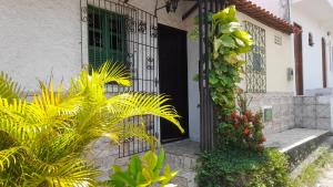 a front door of a house with plants and flowers at Casa na cidade ITAPARICA Bahia -- House in ITAPARICA town in Itaparica Town