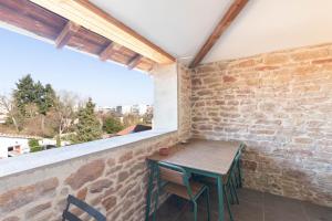 Una mesa y sillas en un balcón con ventana. en Cabana & On dirait le Sud, en Flacé-lès-Mâcon