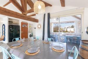 Un comedor con mesa y sillas y una ventana. en Cabana & On dirait le Sud, en Flacé-lès-Mâcon