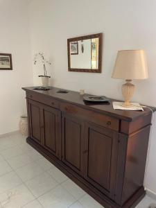 a wooden cabinet with a lamp on top of it at Casa Matilde in Sestu